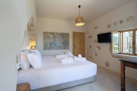 Comfortable Sleeping Area with White Linens and Stone Wall Accents