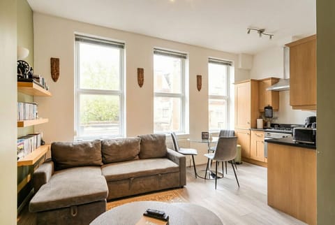 Sun-drenched open-plan living with leafy London rooftop views flooding in.