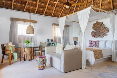 Unwind in your airy suite with canopy bed and lounge.