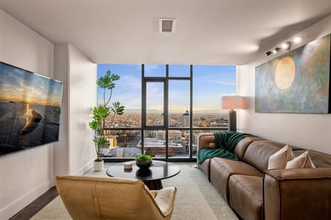 Beautifully designed living room. 75` TV, Leather couch and recliner, floor to ceiling views of amazing views of SLC skyline and the Wasatch  Mountains.