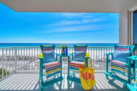 Unwind on your private beachfront balcony with colorful seating and stunning ocean views stretching to the horizon.