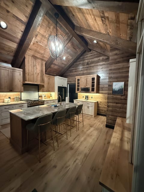 Kitchen with high end appliances and bar stools.