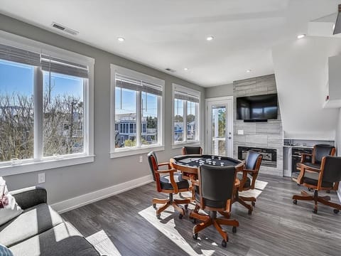 Cozy sunroom, highlighting the comfy seating area and panoramic windows for enjoying the view as well as a fun game with your loved ones.