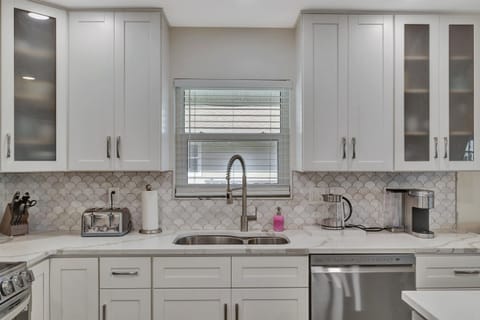 Bright kitchen sink with modern cabinets and stylish backsplash