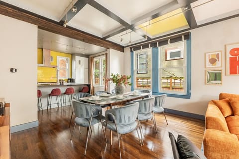 Open dining area with seating for gatherings, flowing seamlessly into a fully equipped, modern kitchen.