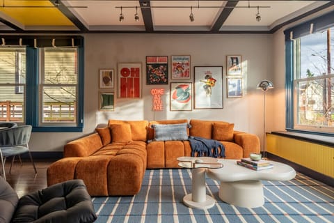 Sun-filled living room with a statement velvet sofa, large windows, and curated art for a warm, stylish retreat.