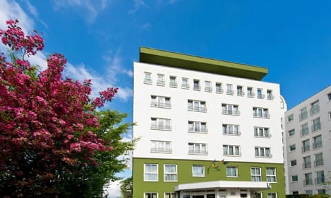 Arrive to a bright, modern façade under blue skies.