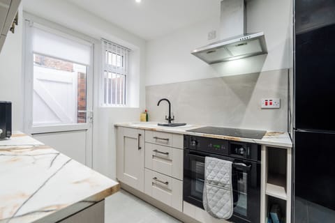 A fully fitted kitchen equipped with everything you need for a comfortable stay, including modern appliances and all the essentials for cooking, dining, and longer visits.