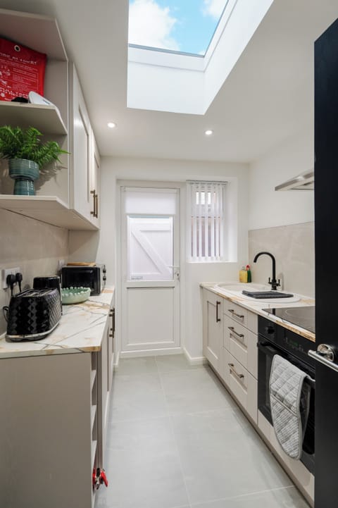 A fully fitted kitchen equipped with everything you need for a comfortable stay, including modern appliances and all the essentials for cooking, dining, and longer visits.
