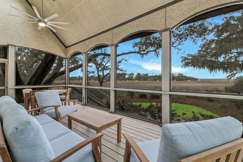 Relax in your screened porch with stunning marsh views, comfortable seating, and gentle ceiling fan breezes.