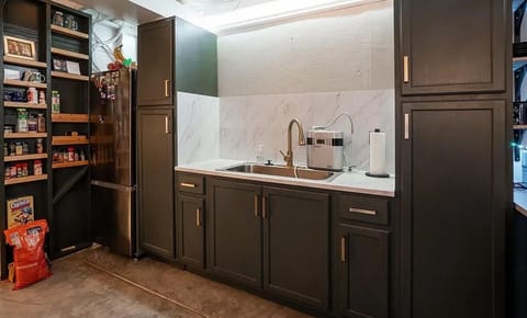 Your fully equipped kitchen features elegant dark cabinetry, marble countertops, and a well-stocked pantry for all your culinary adventures.