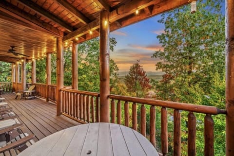 A grand wraparound porch framed by hand-hewn timber columns and glowing string lights. This expansive outdoor living space invites lingering conversations, mountain sunsets, and peaceful mornings surrounded by panoramic forest and mountain vistas.