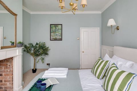 Bright airy bedroom with fireplace and king sized bed 
