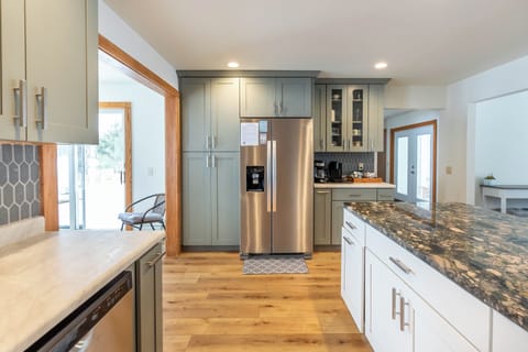 Kitchen - Kitchen has everything you need, including coffee bar! Off to the left is the first dining room. Off to the right is the second dining room. Straight ahead is the home's front entry, laundry room, half bathroom, and entry to the attached main floor apartment.
