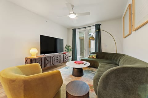 Stretch out in the inviting living room with a plush sofa, oversized TV, and modern design touches throughout.