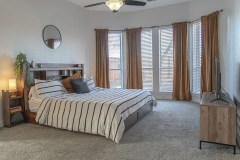 Cozy bedroom with large windows and a peaceful atmosphere.