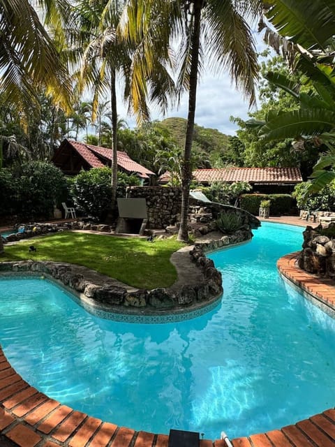 Large shared pool with slide and non-heated jacuzzi, perfect for relaxing and family fun.