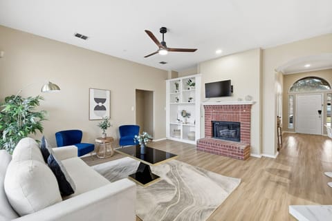Stylish living area featuring a fireplace, built-in shelving, and abundant natural light,perfect for relaxing or entertaining.