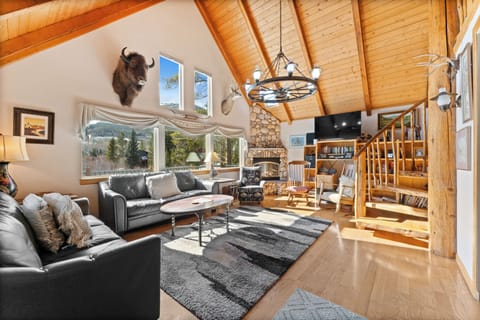 Curl up in this stunning mountain retreat with soaring wood ceilings, cozy fireplace, and panoramic views through expansive windows.