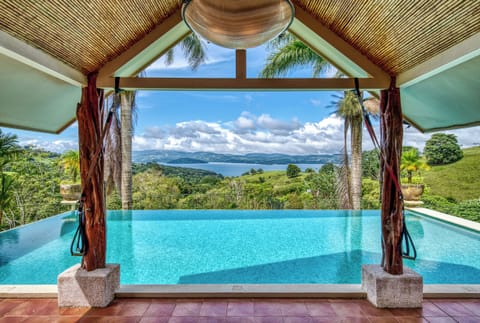 The view through the patio doors of the main home looking past the pool to the lake.