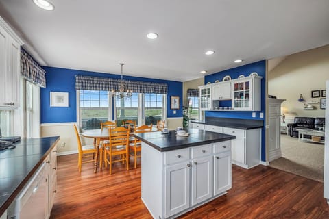 Bright coastal kitchen with a central island and dining area, featuring table seating for six—perfect for meals and gatherings