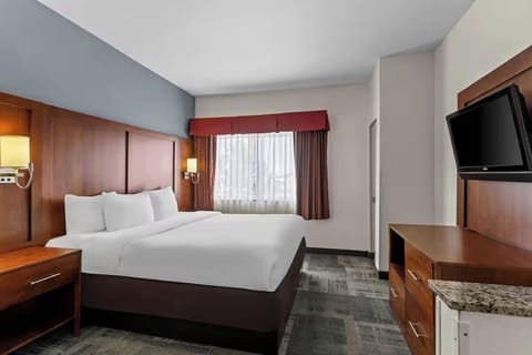 Unwind in a crisp king bed with soft lighting.