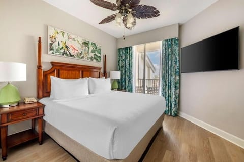 Unwind in a sunlit bedroom with balcony views and TV.