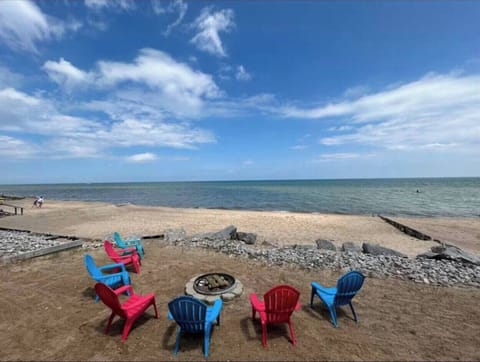 Colorful beachside seating and a fire pit await just steps from the water.