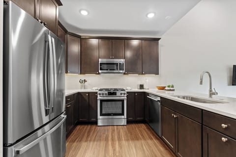 Full kitchen with stainless steel appliances and breakfast bar.