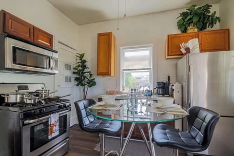 Kitchen & dining area w/ modern touches, bar stools, & open flow.