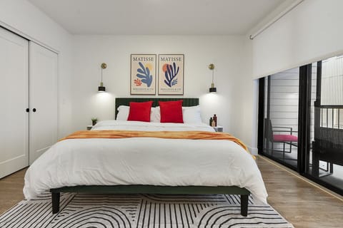 Relax in a luxurious king bed, crisp white linens, and private balcony access – ideal for restful stays near attractions.