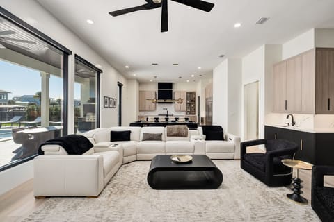 Unwind in your sophisticated open-plan living space with plush seating, modern kitchen, and floor-to-ceiling windows.