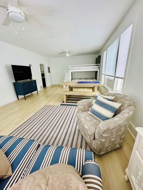 Main living space with living room, dining table, desk,  bunk beds,, smart tv