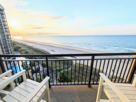 Private ocean-view balcony with sunrise seating above the beach