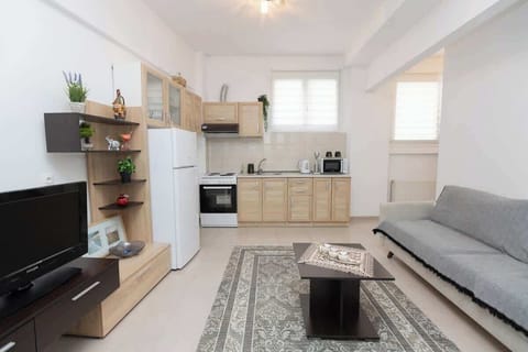 Bright open-plan living area with sofa bed and Smart TV.