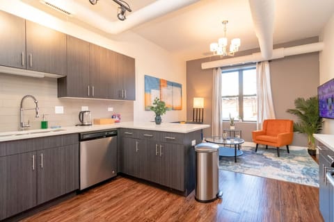Modern open-concept kitchen and living area with sleek cabinetry, breakfast bar seating, and stylish lounge space.