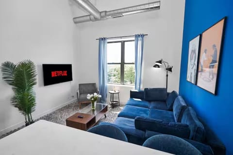 Relax in this bright and stylish living room featuring a plush sectional sofa, comfortable accent seating, and beautiful natural light. Perfect for lounging, movie nights, or spending quality time together.