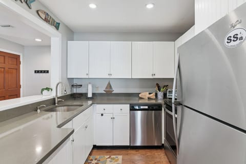 Your fully equipped kitchen features sleek white cabinets, stainless steel appliances, and generous counter space for preparing memorable meals.