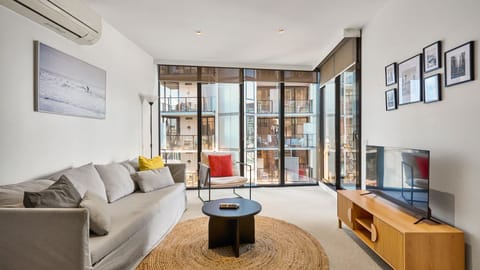 Bright open-plan living area with floor-to-ceiling windows and city views.