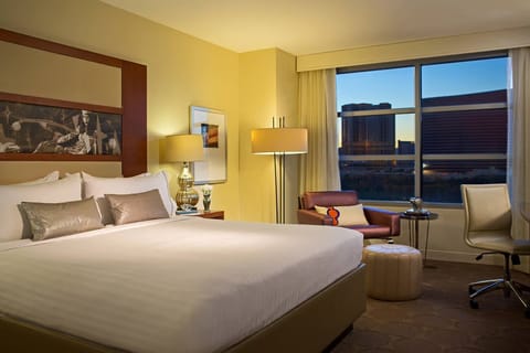 Settle into a spacious king bed with sunset city views.