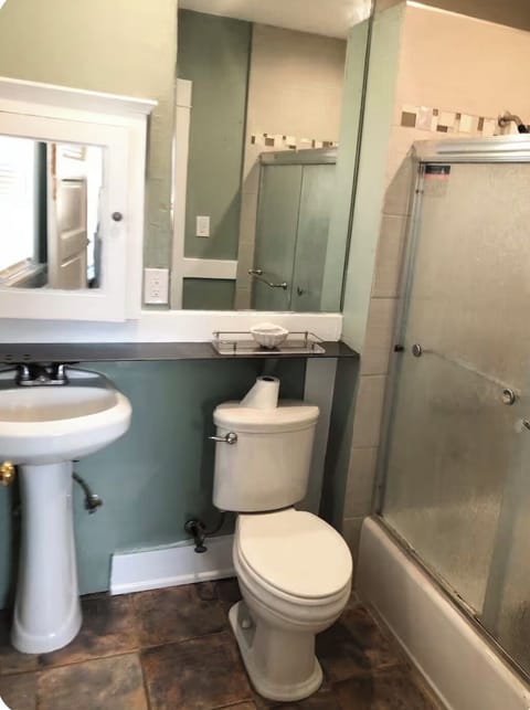 Small bathroom with toilet, sink, and shower.