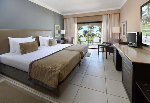Unwind in twin comfort with garden views and cool tile.