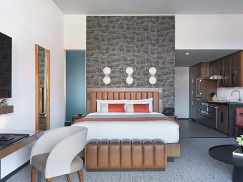 Sink into crisp linens beneath warm, modern statement lighting.