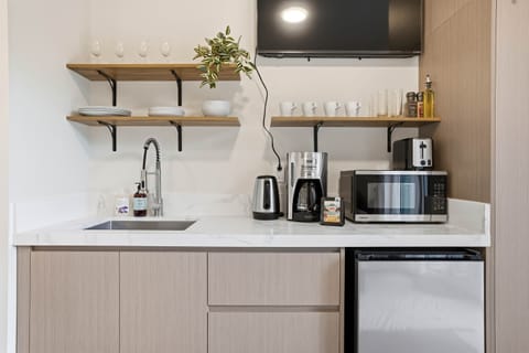 Sink, kettle, coffee machine, microwave, toaster and mini fridge. 