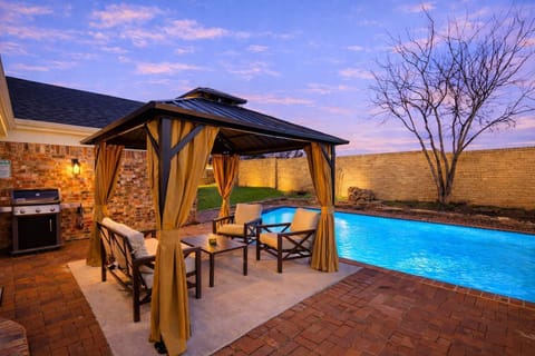 Relax under the covered gazebo beside the sparkling pool—an inviting backyard retreat perfect for evening drinks, quiet conversations, or unwinding after a day of exploring.