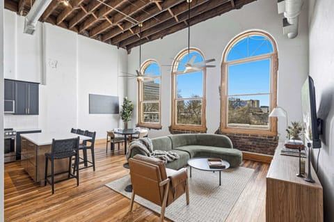 Soaring ceilings and grand arched windows flood the space with natural light, blending historic charm with modern comfort.