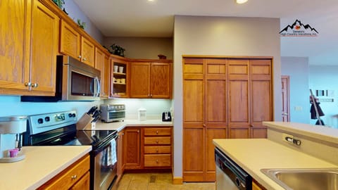 Cook your favorite meals in this fully-equipped kitchen featuring rich wood cabinetry, modern appliances, and ample counter space for all your culinary adventures.