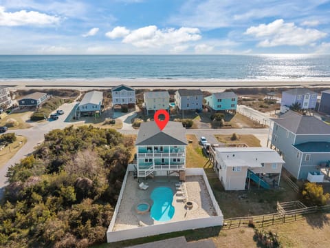 Aerial view of Oak Island NC beach house with private fenced pool, spacious decks, and easy beach access just across the street along the oceanfront homes.