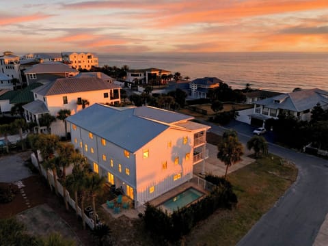 Aerial sunset over the beachside neighborhood—Gulf views, palm-lined streets, and that golden-hour glow.