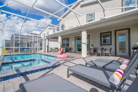 Enjoy relaxing by the pool with a fun swan float and lounging chairs, all under a bright blue sky in this beautiful backyard retreat.